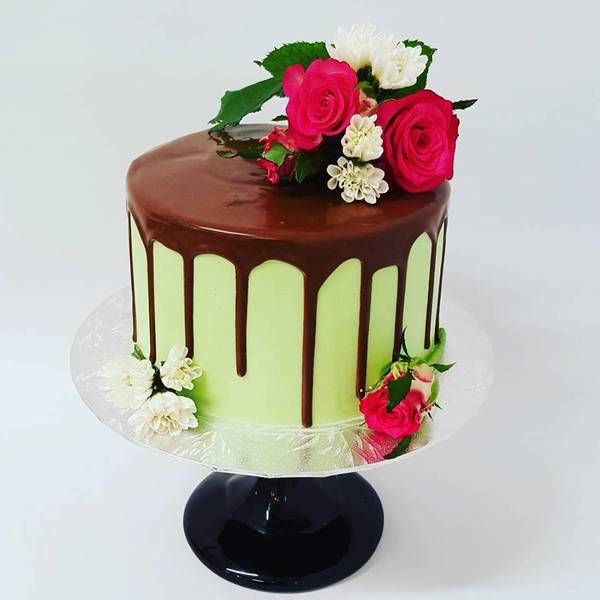 Smooth Green Cake with Chocolate Drip and Fresh Flowers